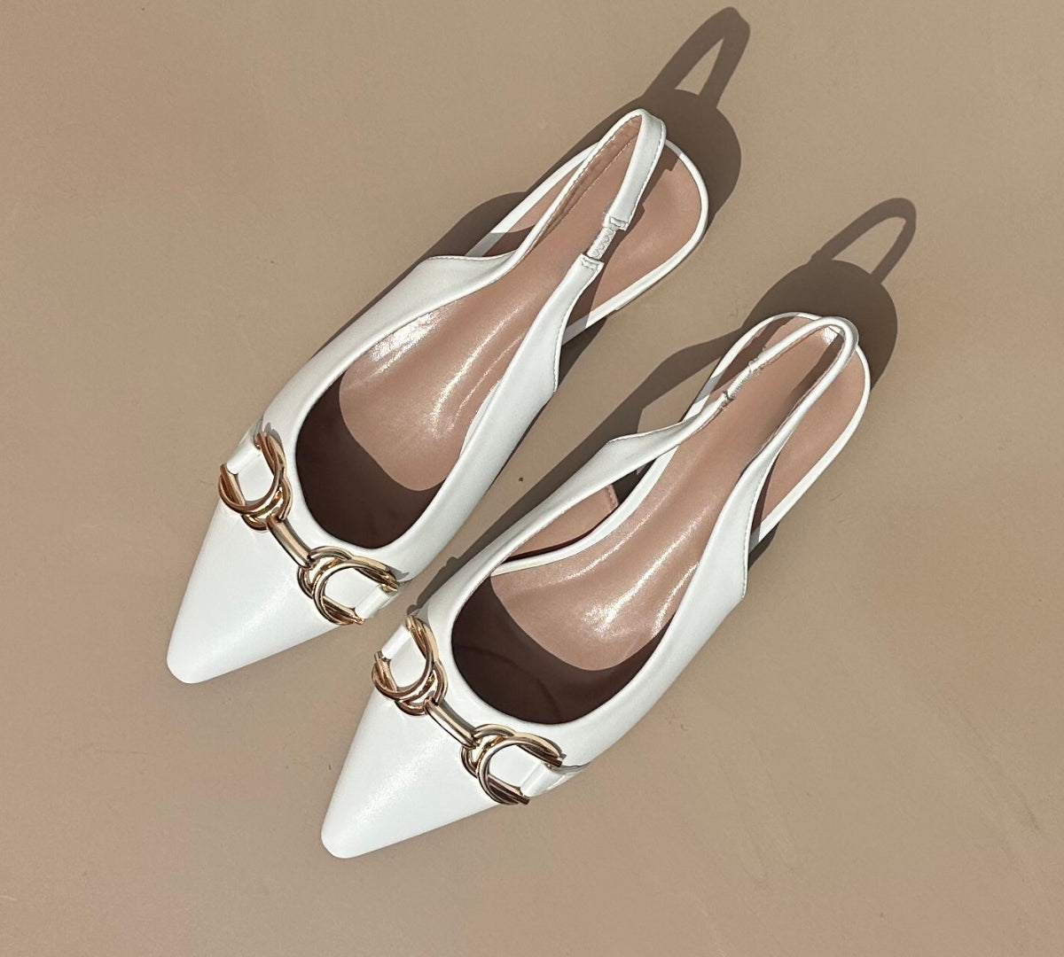 Ballerines slingback en cuir synthétiques Blanches dotées d'un bout pointu avec motif gold. Confortables et élégantes, elles ajoutent une touche de sophistication à toutes vos tenues. Parfaites pour une journée de travail ou une soirée spéciale, ces ballerines sauront vous faire sentir à la fois confortable et chic. Faites-vous plaisir avec ces chaussures classiques et intemporelles.