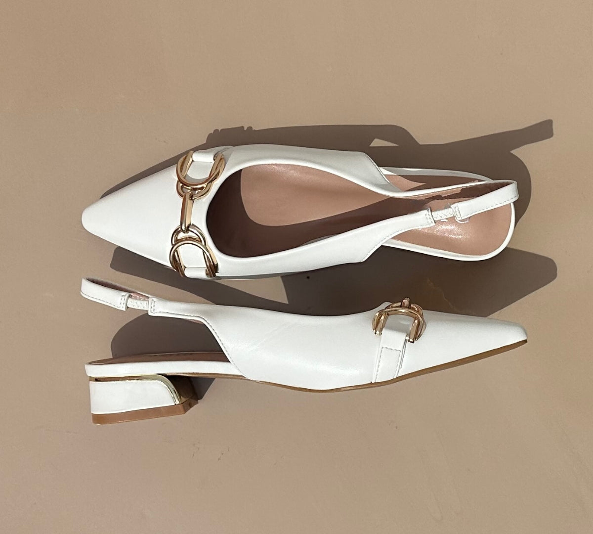 Ballerines slingback en cuir synthétiques Blanches dotées d'un bout pointu avec motif gold. Confortables et élégantes, elles ajoutent une touche de sophistication à toutes vos tenues. Parfaites pour une journée de travail ou une soirée spéciale, ces ballerines sauront vous faire sentir à la fois confortable et chic. Faites-vous plaisir avec ces chaussures classiques et intemporelles.