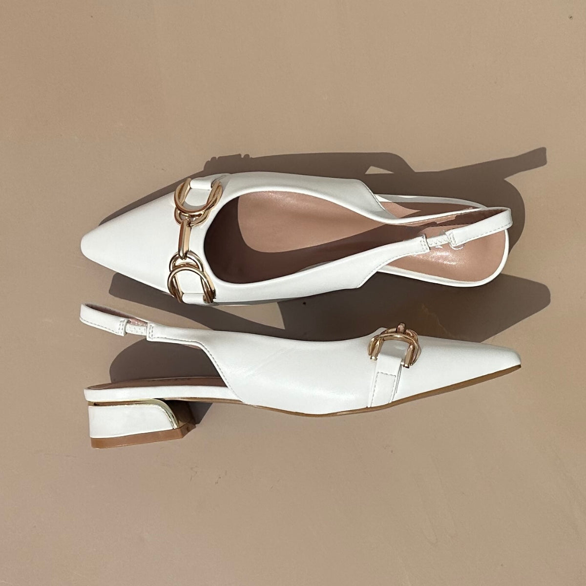 Ballerines slingback en cuir synthétiques Blanches dotées d'un bout pointu avec motif gold. Confortables et élégantes, elles ajoutent une touche de sophistication à toutes vos tenues. Parfaites pour une journée de travail ou une soirée spéciale, ces ballerines sauront vous faire sentir à la fois confortable et chic. Faites-vous plaisir avec ces chaussures classiques et intemporelles.