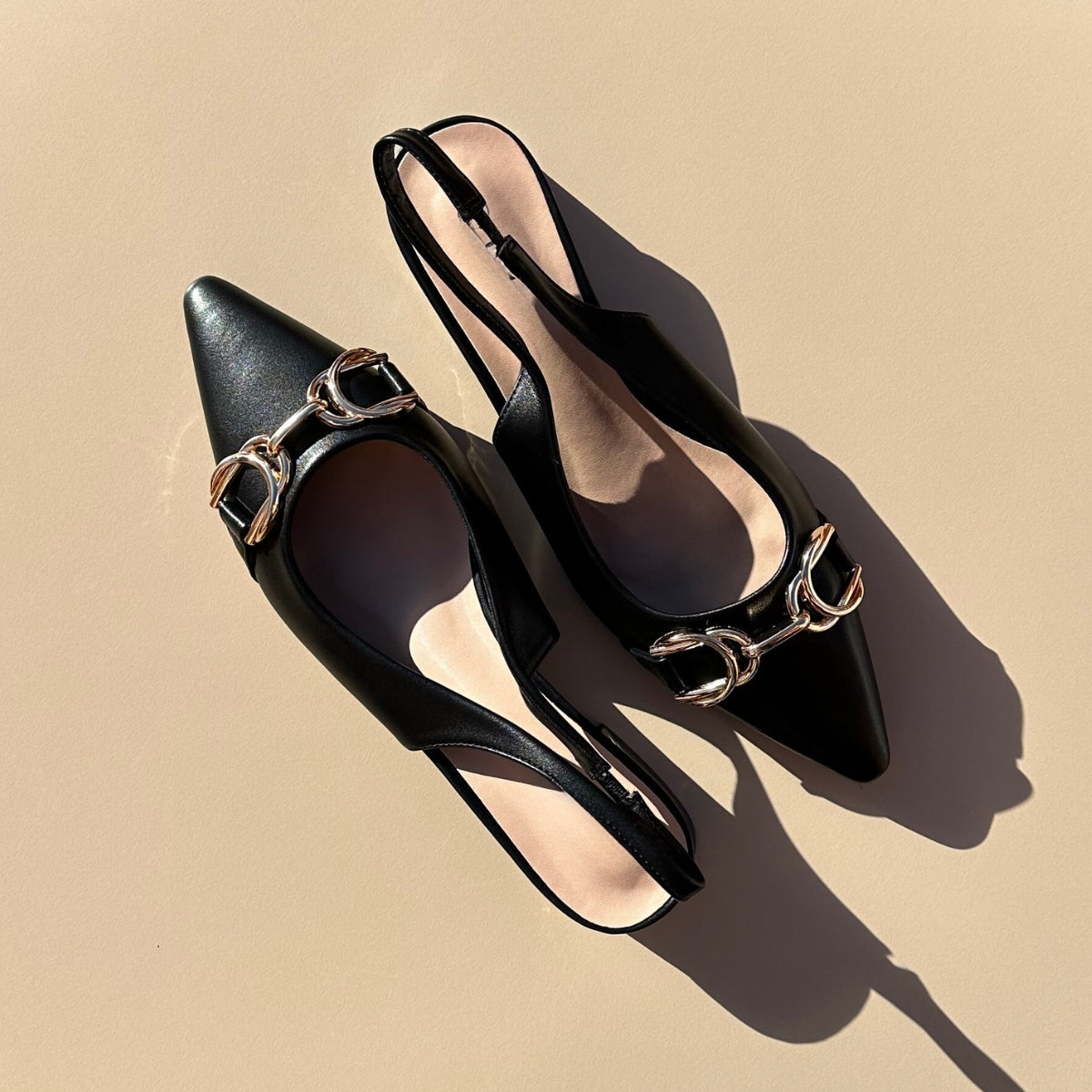 Ballerines slingback en cuir synthétiques noir dotées d'un bout pointu avec motif gold. Confortables et élégantes, elles ajoutent une touche de sophistication à toutes vos tenues. Parfaites pour une journée de travail ou une soirée spéciale, ces ballerines sauront vous faire sentir à la fois confortable et chic. Faites-vous plaisir avec ces chaussures classiques et intemporelles.