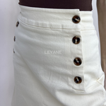 jupe femme, jupe courte beige, jupe taille haute femme, jupe chic femme, jupe boutons décoratifs, jupe élégante femme, jupe casual chic, jupe tendance femme, jupe beige été, jupe mode femme, jupe minimaliste femme, jupe style élégant, jupe moderne femme.